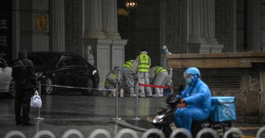 Health workers wearing personal protective equipment (PPE) stand at the entrance to the Legendale Hotel in the Wangfujing shopping district after China reported virus outbreaks in three cities, including the capital, Beijing, July 29, 2021. (AFP Photo)