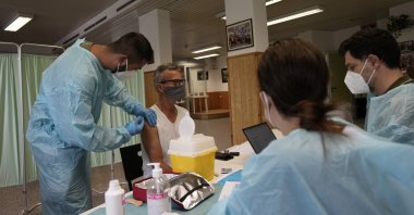 Medical workers administer the Johnson & Johnson vaccine for COVID-19 to Carlo Picella at a cultural center on the outskirts of Milan, Italy, July 28, 2021. (AP Photo)
