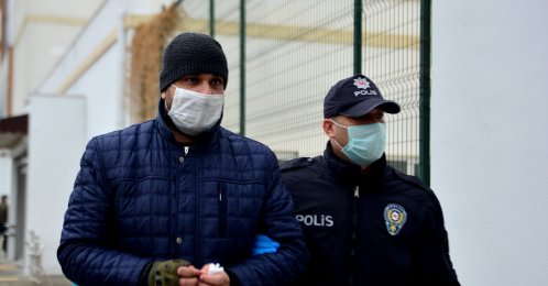 A police officer escorts the suspect after his detention, in Adana, southern Turkey, Feb. 10, 2021. (DHA PHOTO)