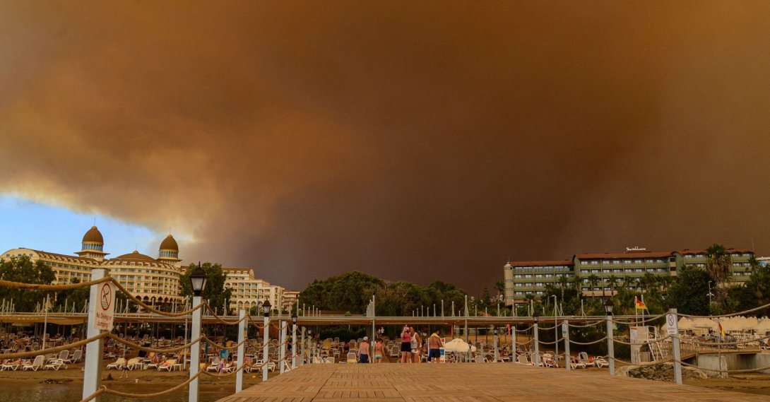 Dark smoke drifts over a hotel complex during a massive forest fire that engulfed a Mediterranean resort region on the southern coast near the town of Manavgat, Antalya, southern Turkey, July 29, 2021. (AFP Photo)