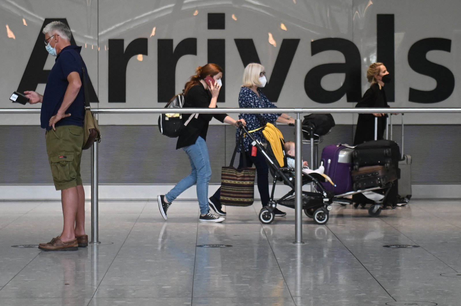Passengers push their luggage on arrival in Terminal 5 at Heathrow Airport in London, U.K, June 3, 2021. (AFP Photo)