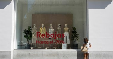 A woman with a shopping bag stands outside a shop at a commercial district in Madrid, Spain, July 27, 2021. (Reuters Photo)