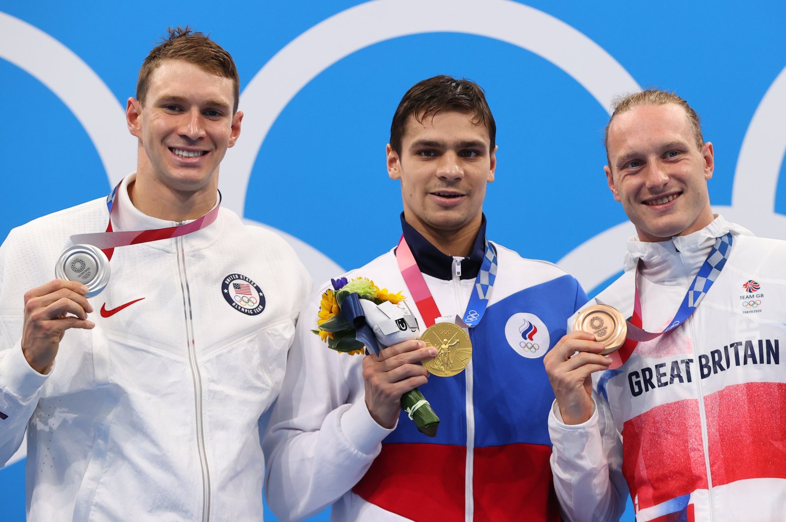 Evgeny Rylov of the Russian Olympic Committee (C), Ryan Murphy of the U.S. (L) and Luke Greenbank of Britain pose on the podium with the gold, silver and bronze medals respectively at Tokyo Aquatics Centre, in Tokyo, Japan, July 30, 2021. (Reuters Photo)