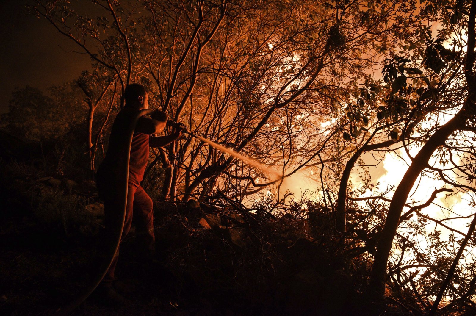 A firefighter battles with fires near the town of Manavgat, in Antalya province, southern Turkey, July 30, 2021. (AP Photo)