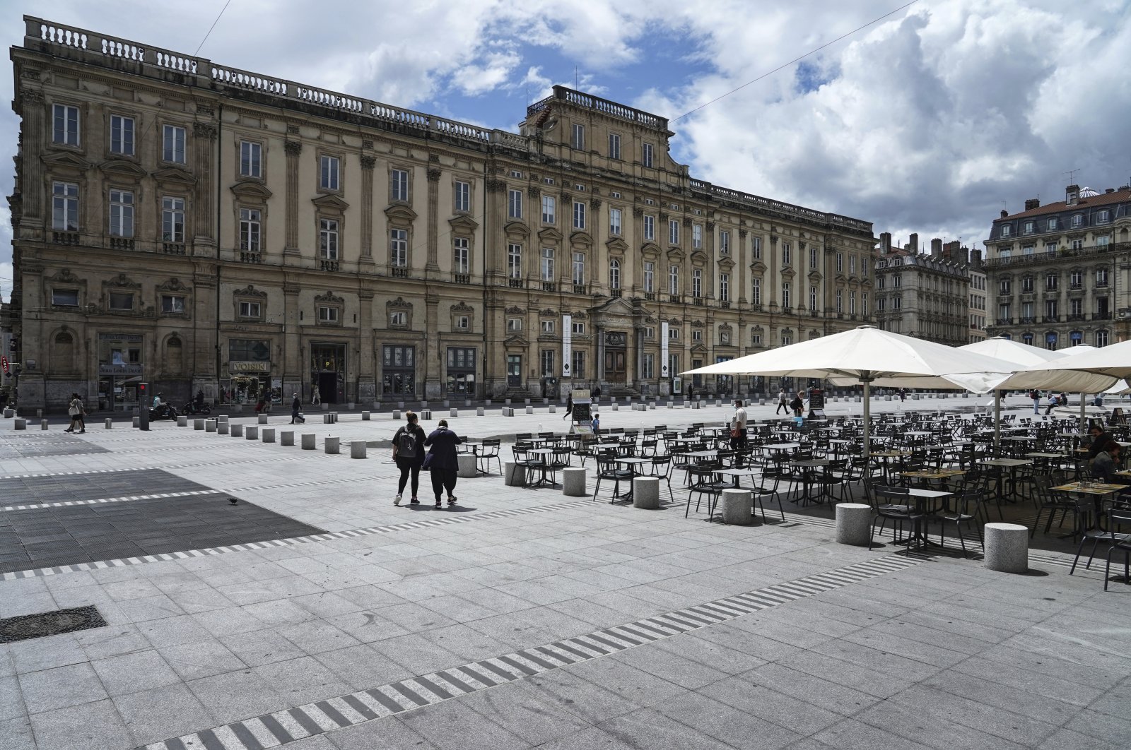 People walk by a terrace restaurant in Lyon, central France, July 13, 2021. (AP Photo)