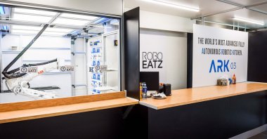 An interior view of the Roboeatz eatery with a view of the robot seen behind glass as it prepares food (L) before placing it on the pick-up counter (R) in Riga, Latvia, May 25, 2021. (AFP Photo).