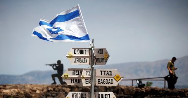 An Israeli soldier stands next to signs pointing out distances to different cities, on Mount Bental, an observation post that overlooks the Syrian side of the Quneitra crossing, Israeli-occupied Golan Heights, May 10, 2018. (Reuters Photo)