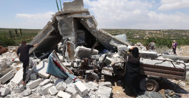 People salvage belongings from a house destoyed by a Russian missile attack in the Jabal al-Zawiya region in the south of Syria's opposition-held Idlib province, on July 4, 2021. (AFP Photo)