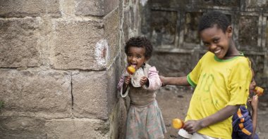 Children play and eat ice pops on a street in Gondar, in the Amhara region of northern Ethiopia, on May 1, 2021. (AP Photo)