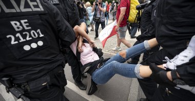Police arrest a demonstrator at an unannounced demonstration against COVID-19 restrictions at the Victory Column, in Berlin,  Germany, Aug. 1, 2021. (dpa via AP)