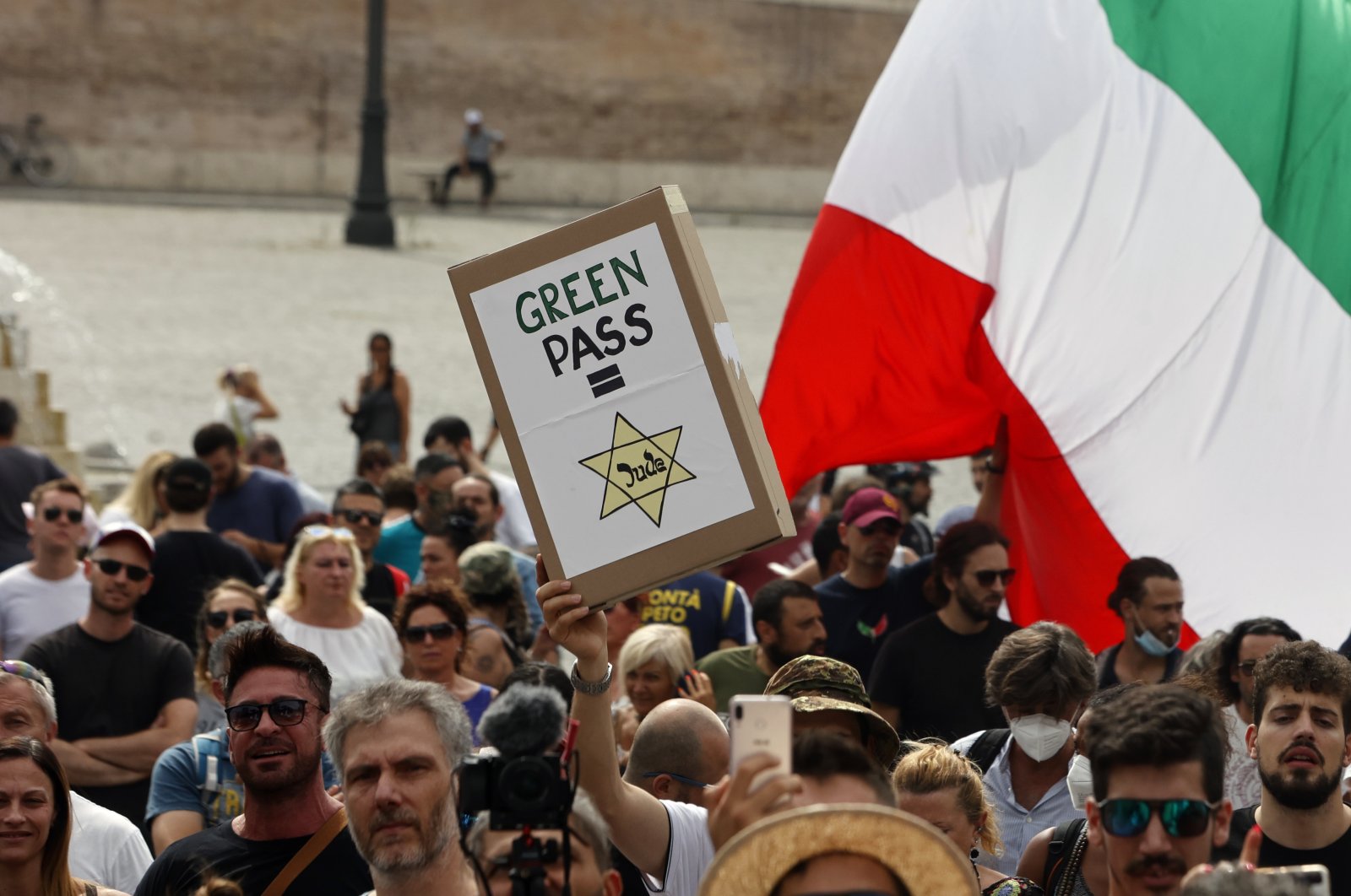People gather to protest against the COVID-19 vaccination pass in Rome. Protesters in Italy and in France have been wearing yellow Stars of David, like the ones Nazis required Jews to wear to identify themselves during the Holocaust, July 27, 2021. (AP Photo)