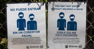 A sign by the entrance of a COVID-19 vaccine clinic at the Para Los Ninos building organized by Walmart and Para Los Ninos reads "You may not enter without wearing a mask even if you are fully vaccinated" in East Hollywood, California, U.S., 31 July 2021.  (EPA Photo)