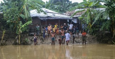 Rohingya refugees look at floodwater following heavy rains at the Rohingya refugee camp in Kutupalong, Bangladesh, July 28, 2021. (AP Photo)