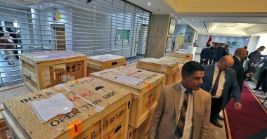 Staff members at Iraq's Ministry of Foreign Affairs work around crates of looted Iraqi antiquities returned by the United States, ahead of a handover ceremony at the ministry in the capital Baghdad, on Aug. 3, 2021. (AFP Photo)
