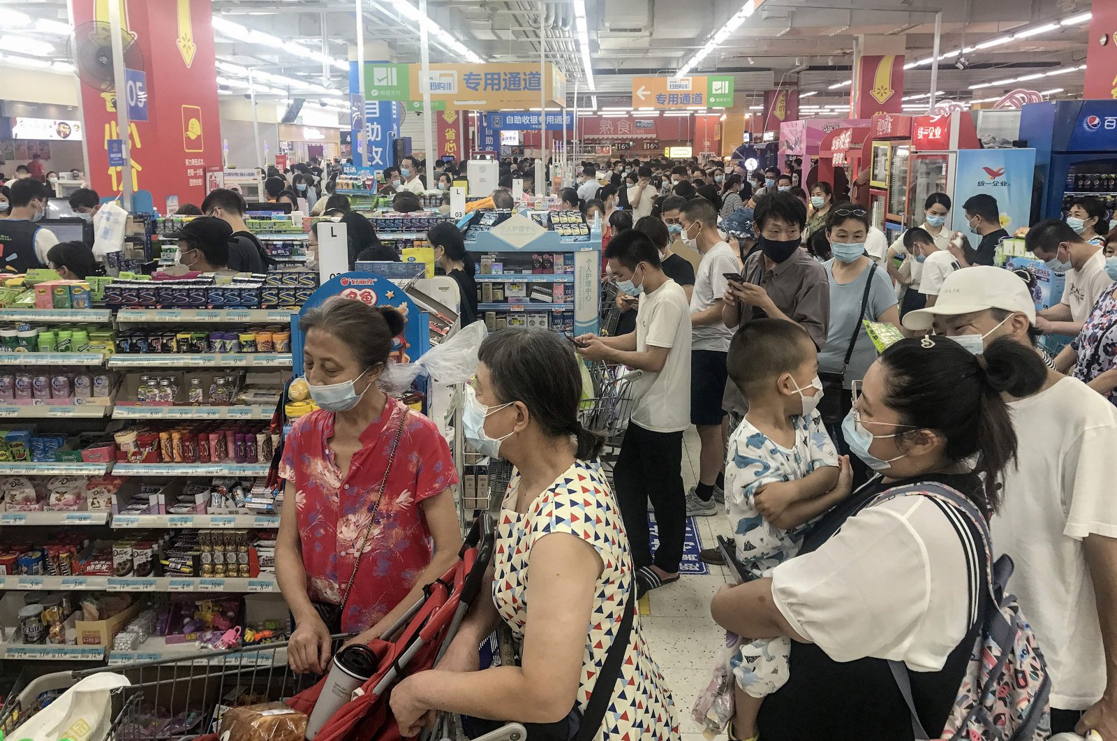 People buying items at a supermarket in Wuhan, in China's central Hubei province, as authorities said they would test its entire population for COVID-19 after the central Chinese city where the coronavirus emerged reported its first local infections in more than a year, Aug. 2, 2021. (AFP Photo)