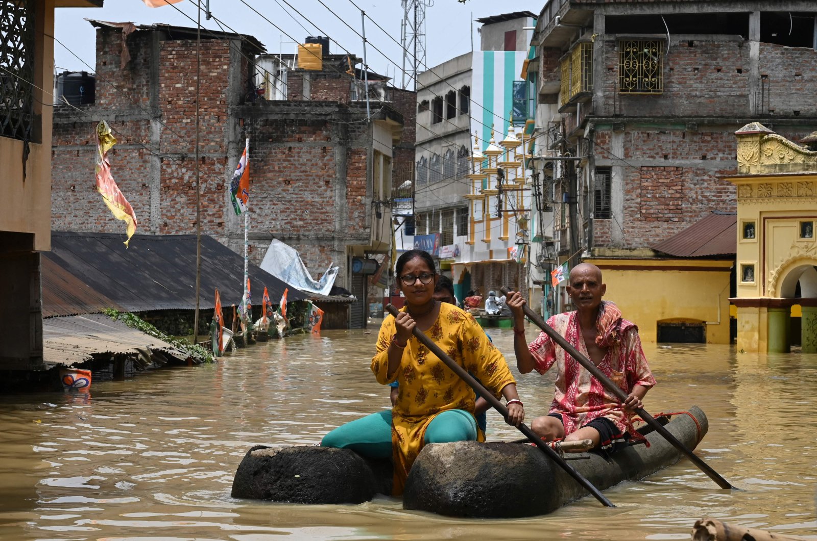 Residents ride a boat over a road submerged by floodwaters following heavy monsoon rains in Ghatal, around 100 kilometers (61 miles) from Kolkata, India, Aug. 2, 2021. (AFP Photo)