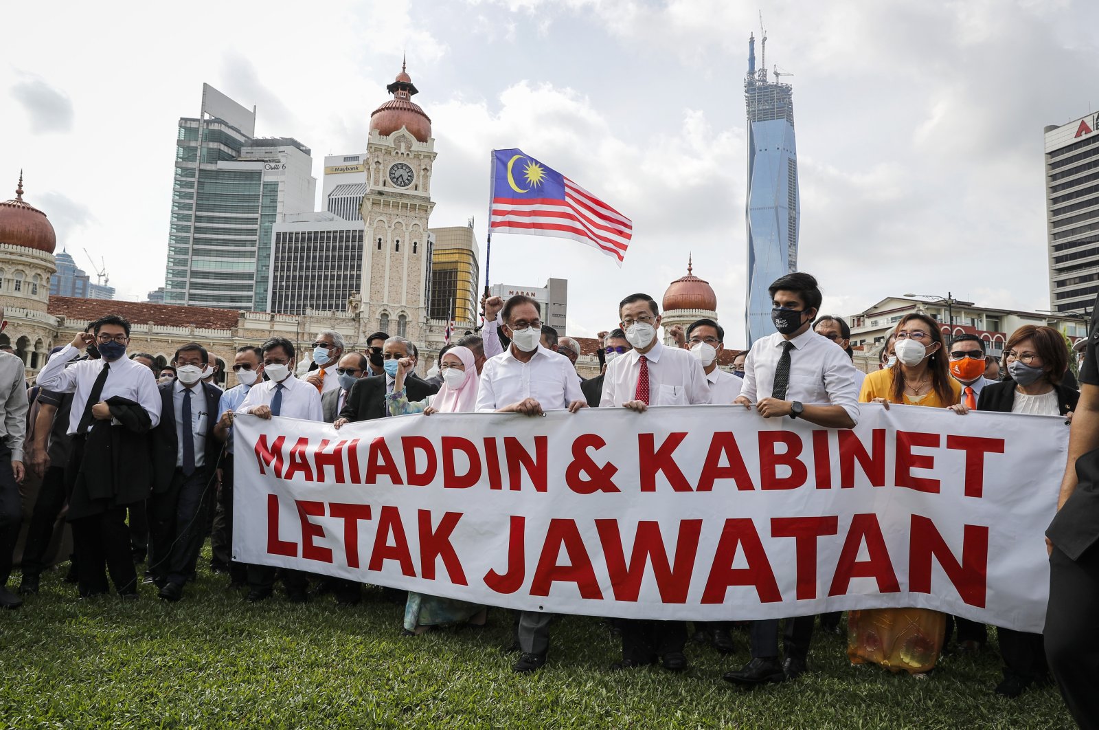 Malaysian opposition members Anwar Ibrahim, (4-L), and Mahathir Mohamad, (2-L), hold a banner reading "Muhyiddin and Cabinet resign" during a protest in Kuala Lumpur, Malaysia, Monday, Aug. 2, 2021. (AP Photo)