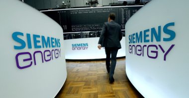 A trader walks next to Siemens Energy AG logos during Siemens Energy's initial public offering (IPO) at the Frankfurt Stock Exchange in Frankfurt, Germany, Sept. 28, 2020.  (Reuters Photo)
