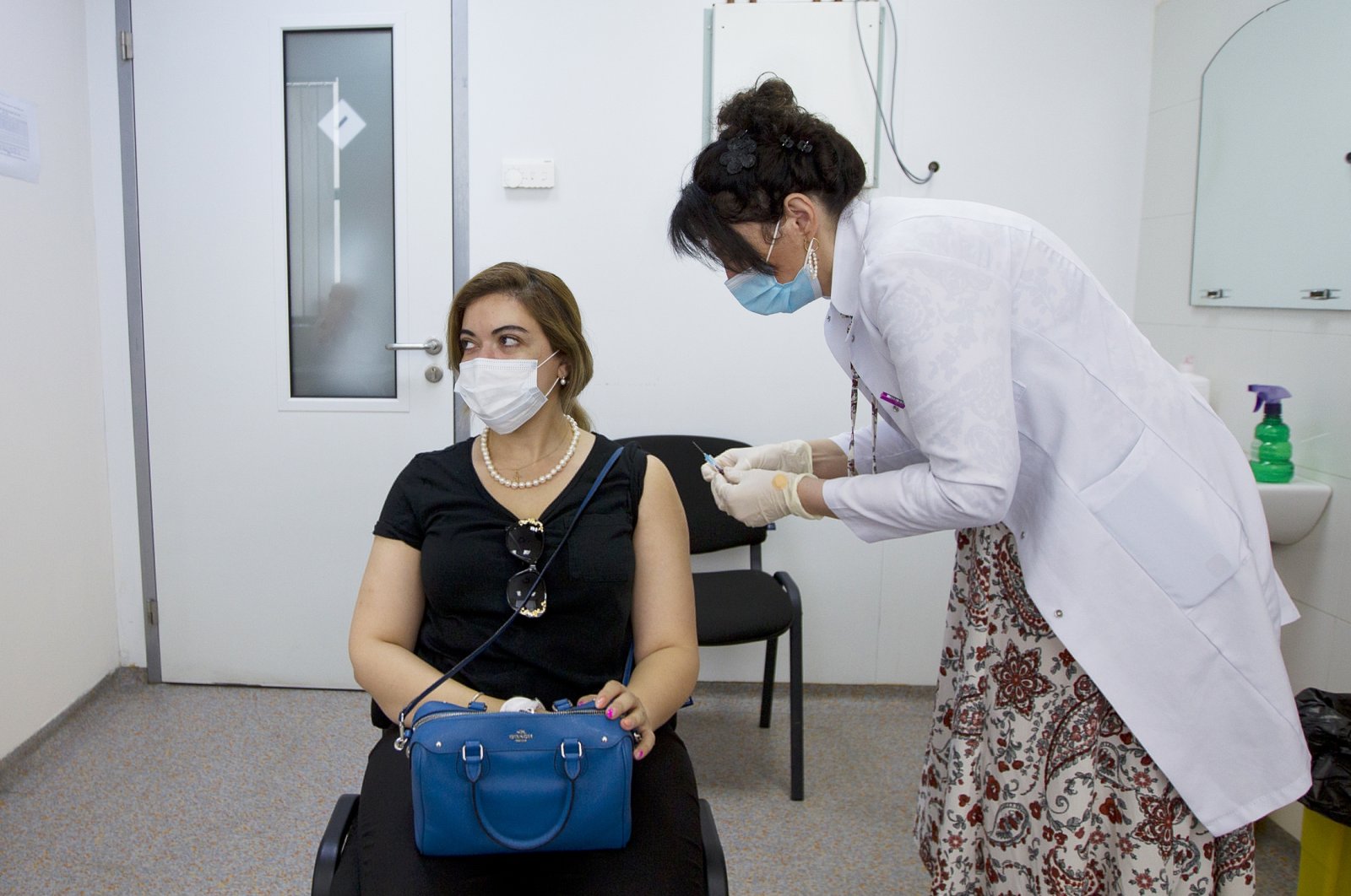 A medical worker prepares to give an injection of Pfizer coronavirus vaccine to a woman in Tbilisi, Georgia, July 27, 2021. (AP Photo)