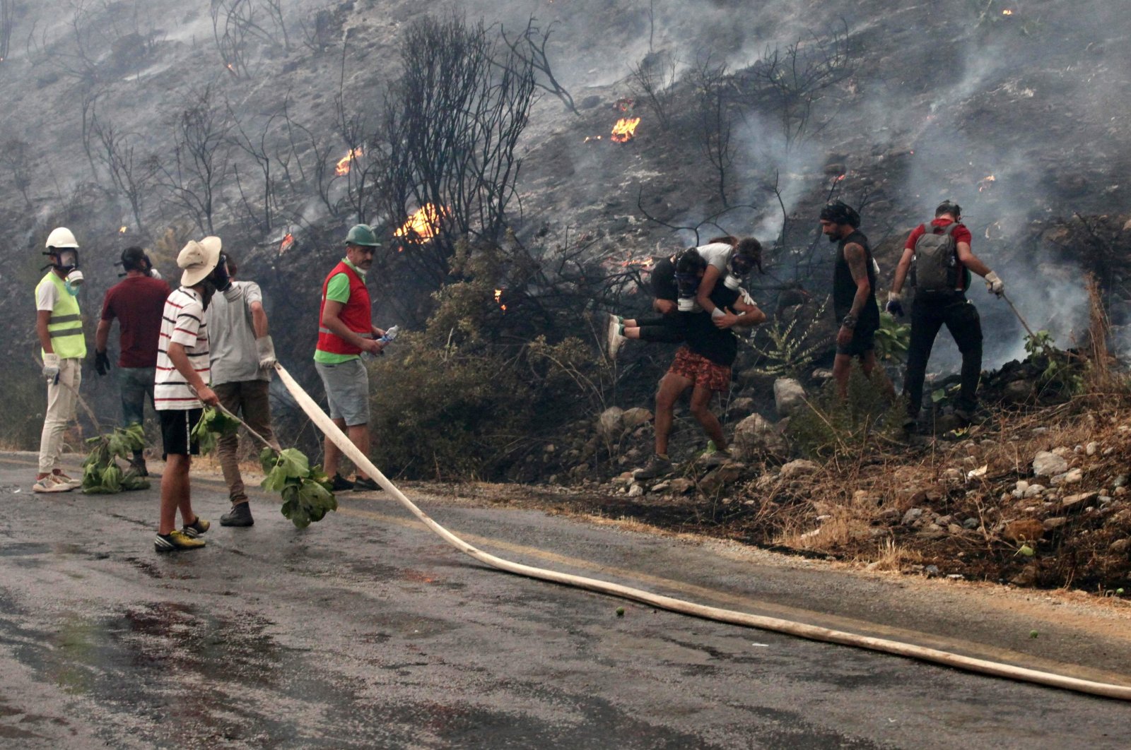Fire crews, helped by locals, work to put out a fire in Ören district, Muğla, southwestern Turkey, Aug. 3, 2021. (AFP PHOTO)