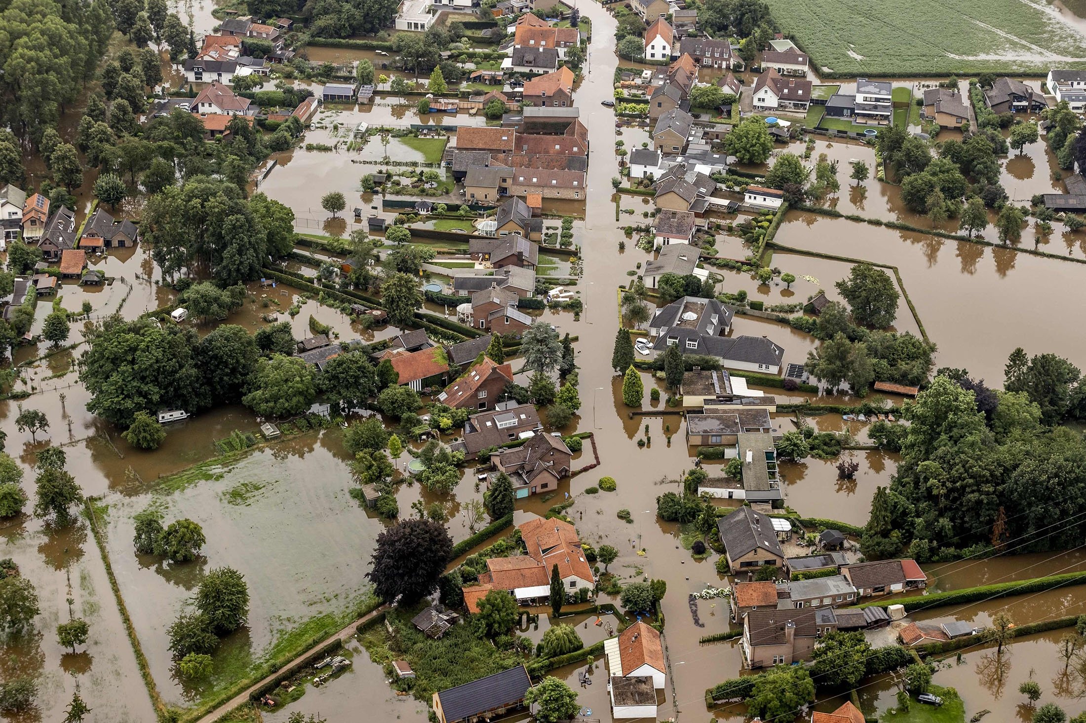 This aerial photo taken in Brommelen shows the flooded area around the Meuse after a levee of the Juliana Canal broke, the Netherlands, July 16, 2021. (AFP Photo)