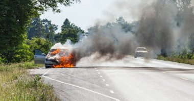 A burning car on a road. (Shutterstock Photo)