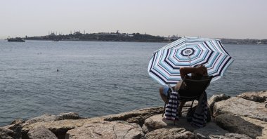 A swimmer on the Salacak coast rests under an umbrella in Istanbul, Turkey, July 31, 2021. (AA PHOTO)