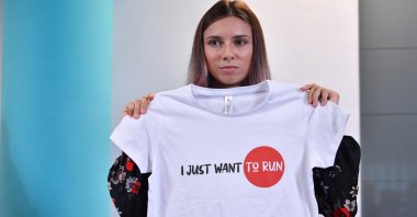 Belarusian sprinter Krystsina Tsimanouskaya, who left the Olympic Games in Tokyo and seeks asylum in Poland, holds a t-shirt at a news conference in Warsaw, Poland, Aug. 5, 2021. (Reuters Photo)