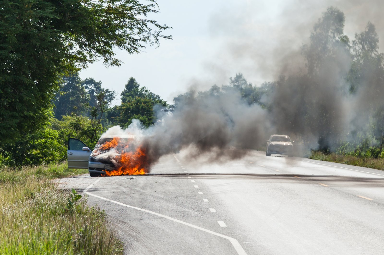 A burning car on a road. (Shutterstock Photo)