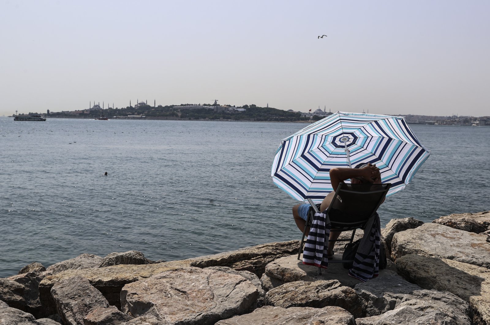A swimmer on the Salacak coast rests under an umbrella in Istanbul, Turkey, July 31, 2021. (AA PHOTO)
