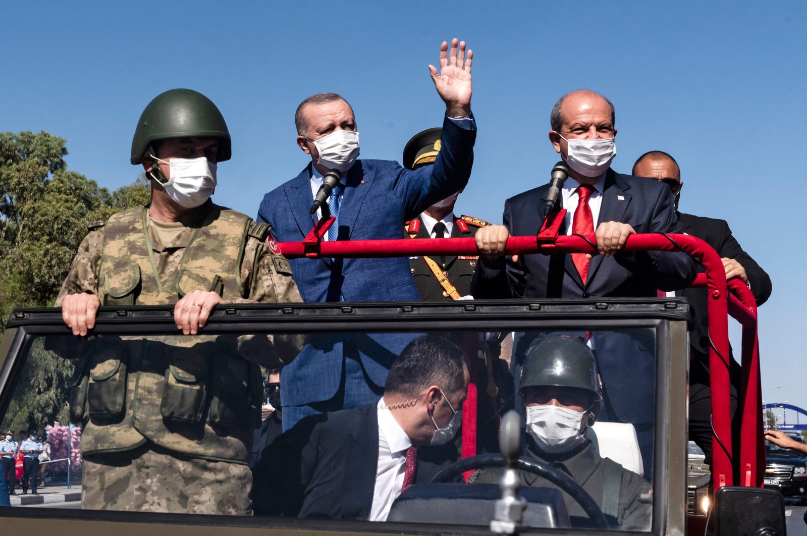 Turkish Cypriot President Ersin Tatar (C-R) and his Turkish counterpart Recep Tayyip Erdoğan (C-L) wave as they take part in a parade in the Turkish Republic of Northern Cyprus, July 20, 2021. (AFP Photo)