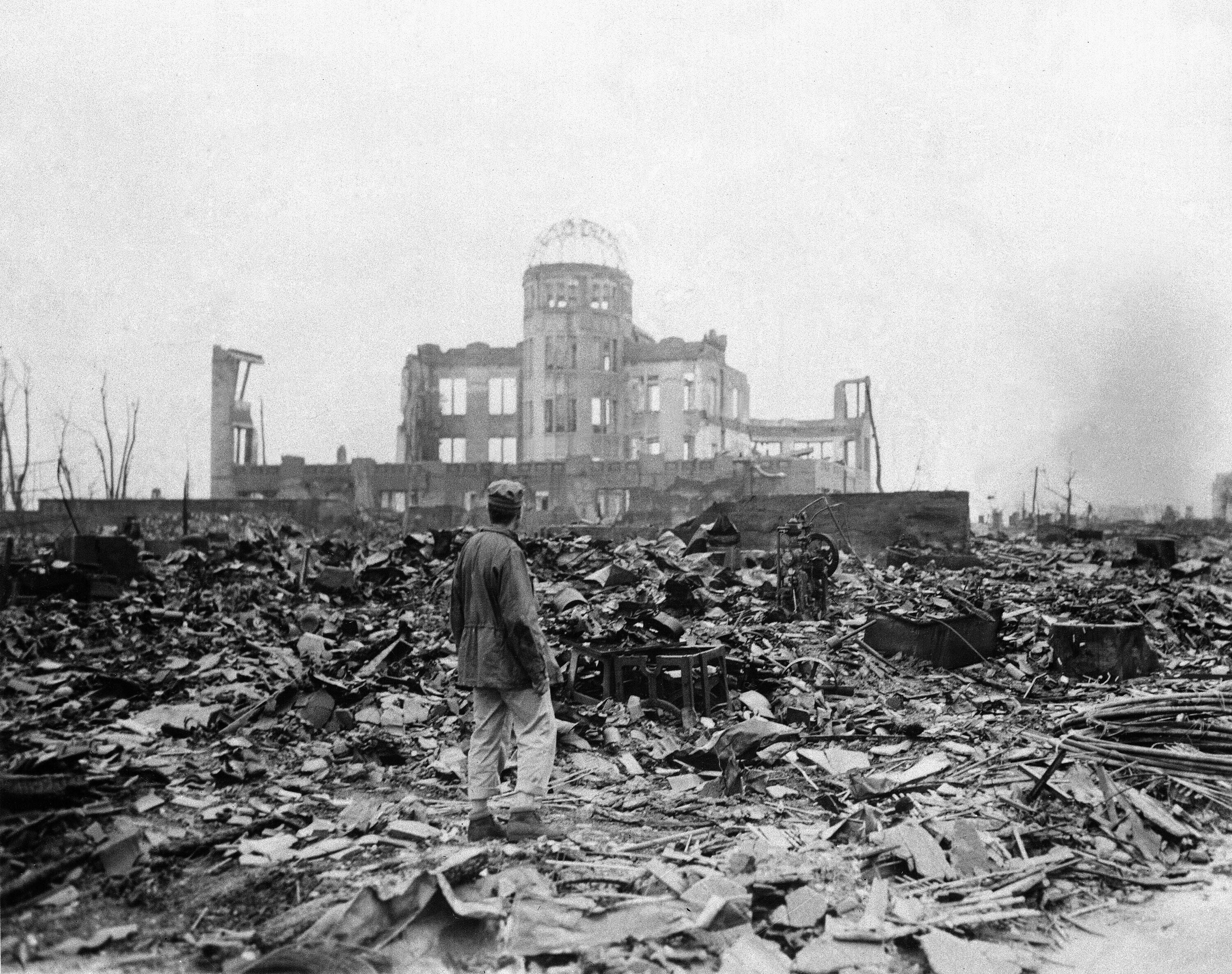 An allied correspondent stands in a sea of rubble before the shell of a building that once was a movie theater in Hiroshima, western Japan, Sept. 8, 1945. (AP Photo)
