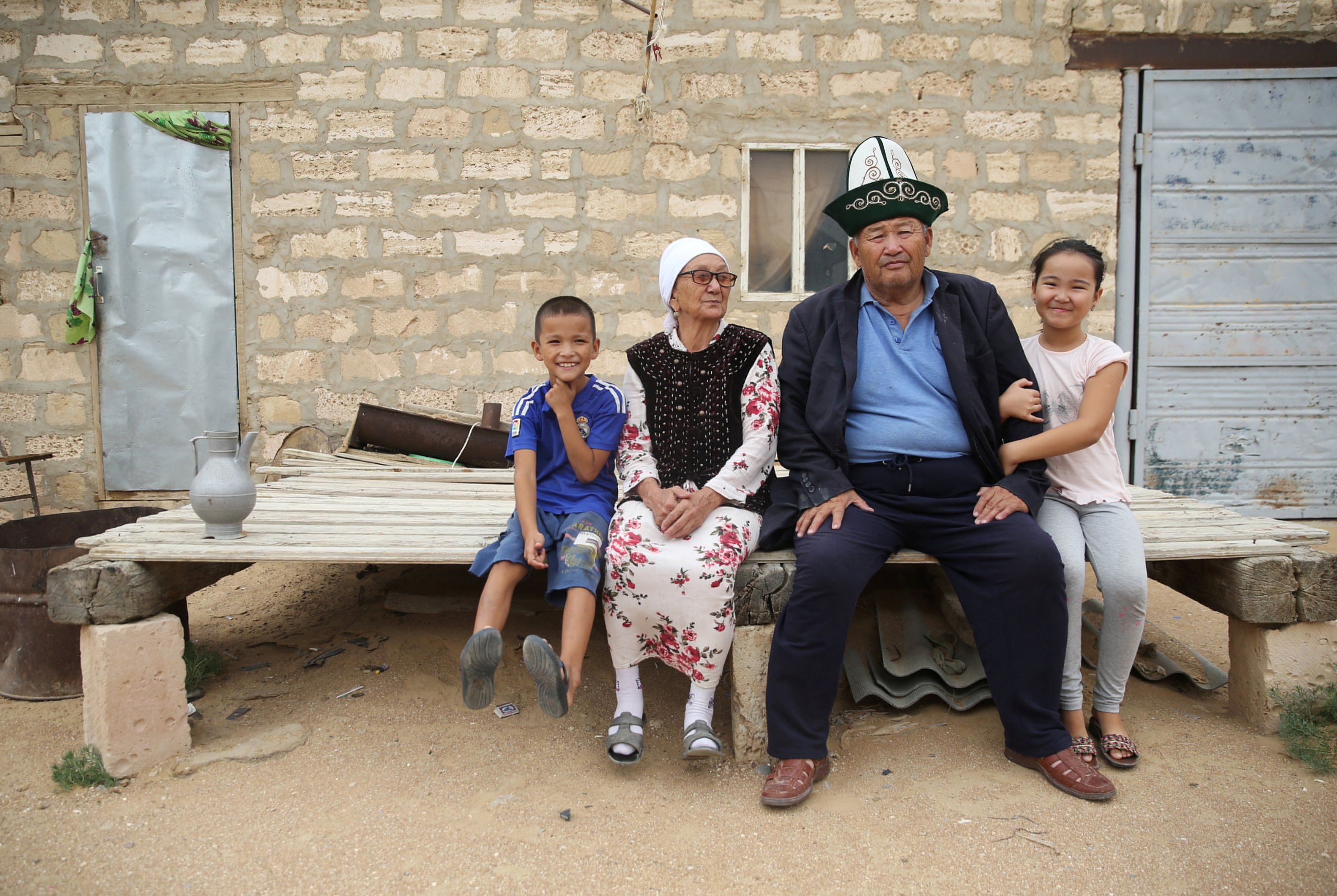 Farmer Gabidolla Kalynbayuly, 70, poses with his family members next to their house in the village of Akshymyrau amid severe drought in Mangistau Region, Kazakhstan, on July 27, 2021. (Reuters Photo)