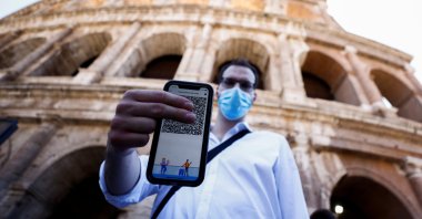 A man shows his Green Pass (health pass) before entering the Colosseum as Italy brings in tougher restrictions where proof of immunity will be required to access an array of services and leisure activities in Rome, Italy, August 6, 2021. (Reuters Photo) 