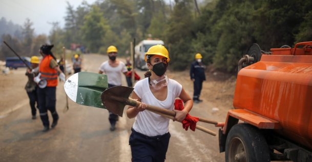 Volunteers run as they fight wildfires in Turgut village, near tourist resort of Marmaris, in Muğla, southwestern Turkey, Aug. 4, 2021. (AP PHOTO) 