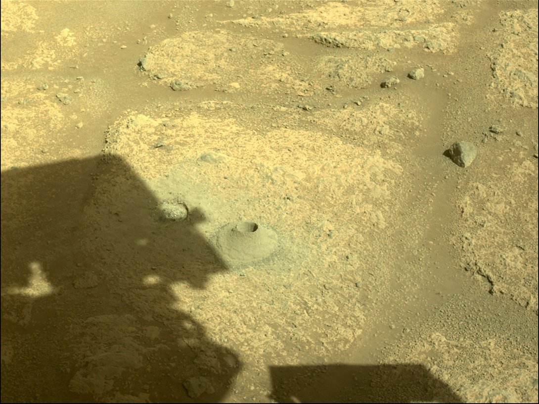 The shadow of the Perseverance Mars rover is cast next to its first hole drilled in a rock, Aug. 6, 2021. (AFP Photo/NASA/JPL-Caltech)