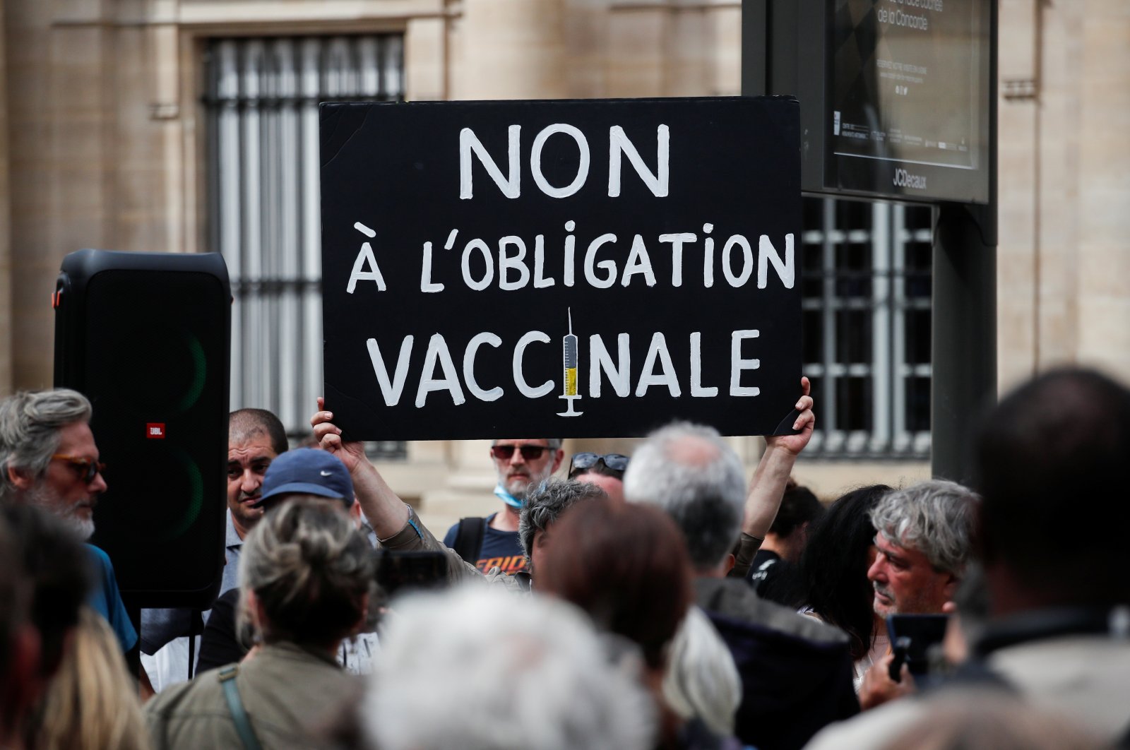 A protester holds a placard during a demonstration called by the "yellow vests" (gilets jaunes) movement against France's restrictions, including a compulsory health pass, to fight the coronavirus outbreak in Paris, France, Aug. 5, 2021. (Reuters)