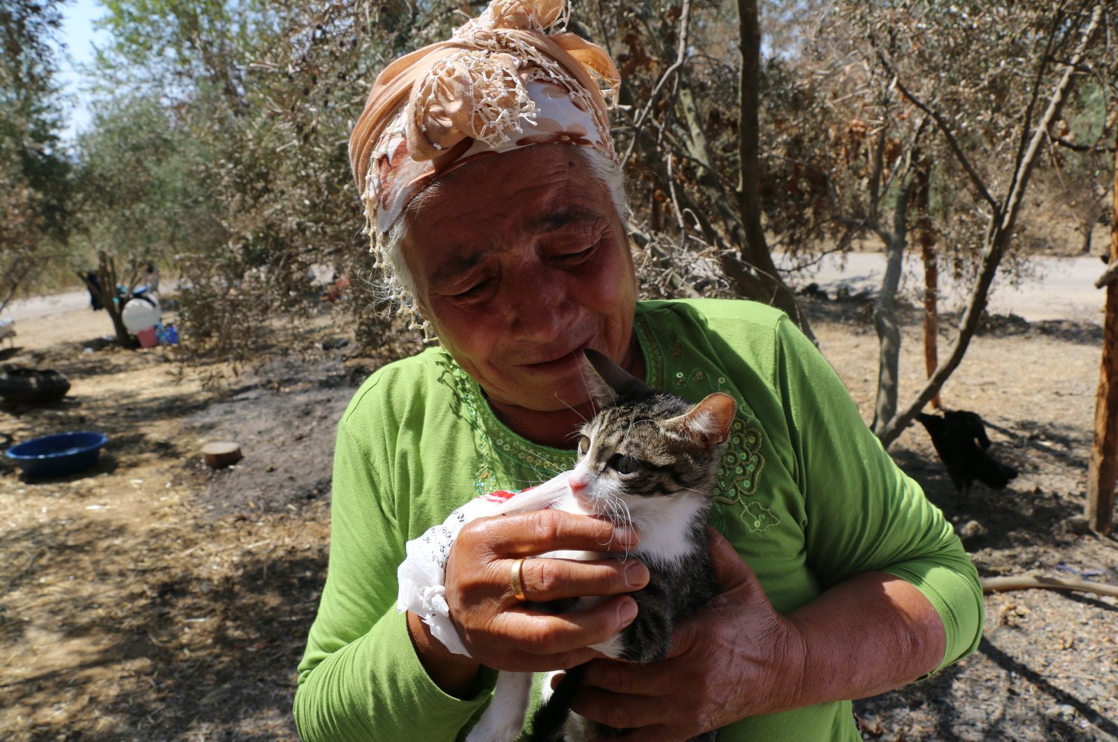 Fatma Duysak pets her cat "Hayat" who recovered after suffering injuries due to the wildfire, in Aladağ district, in Adana, southern Turkey, Aug. 6, 2021. (AA PHOTO)