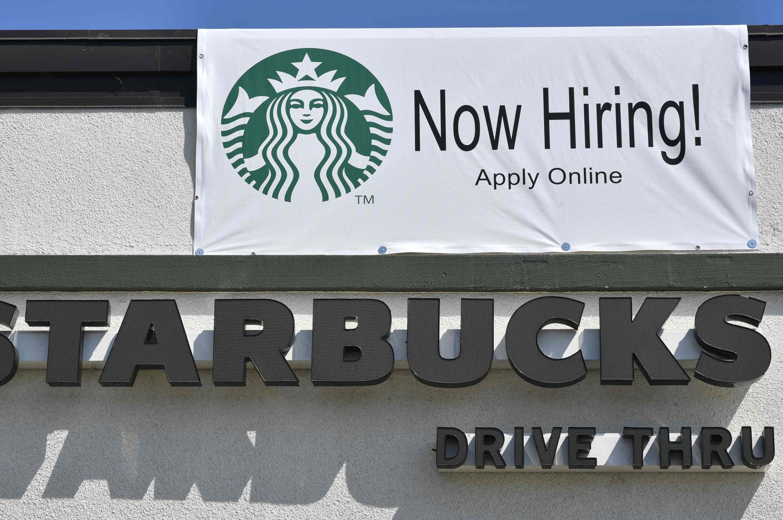 A "Now Hiring" sign is displayed outside a Starbucks coffee shop in Glendale, California, US, July 7, 2021. (AFP Photo)