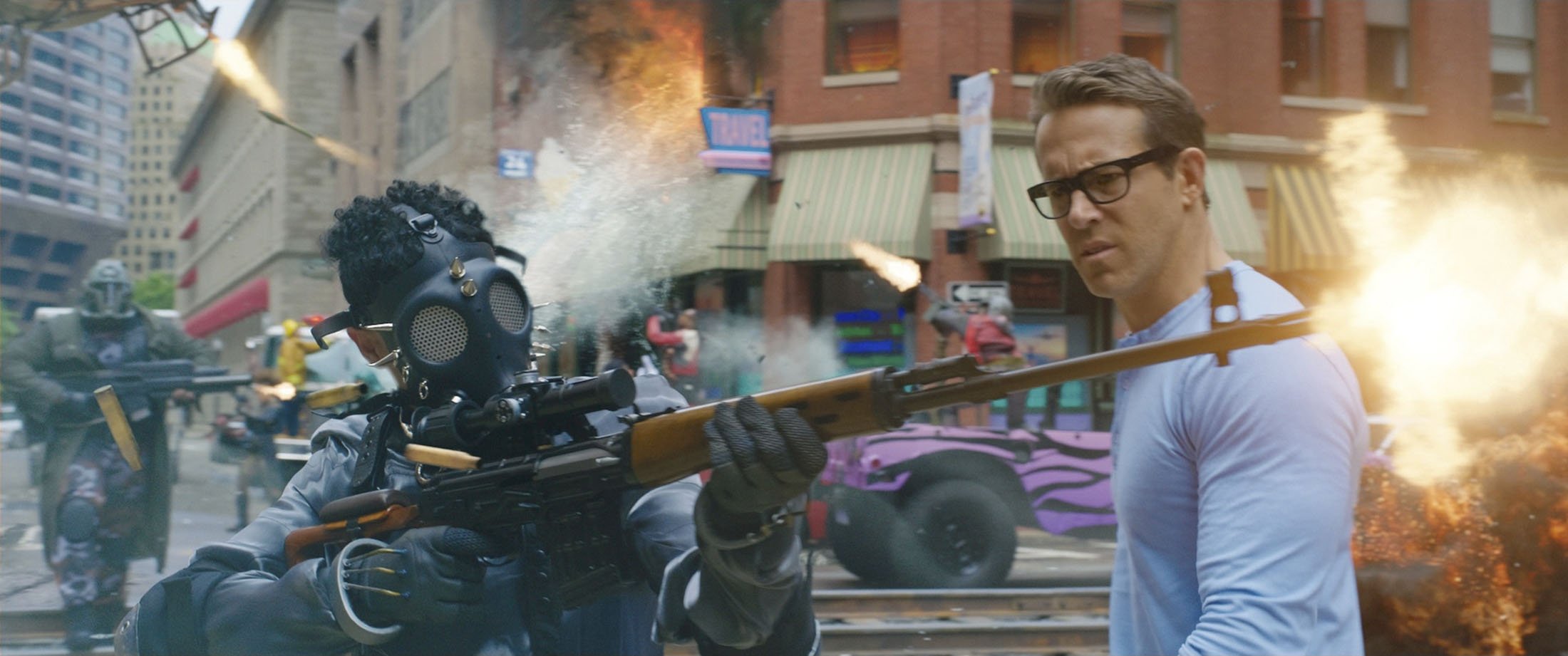 Ryan Reynolds (R) is in the middle of a chaotic scene in the movie 