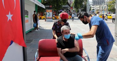 A healthcare worker administers a dose of COVID-19 vaccine to a man at Kizilay Square in Ankara, on July 11, 2021. (AFP Photo)