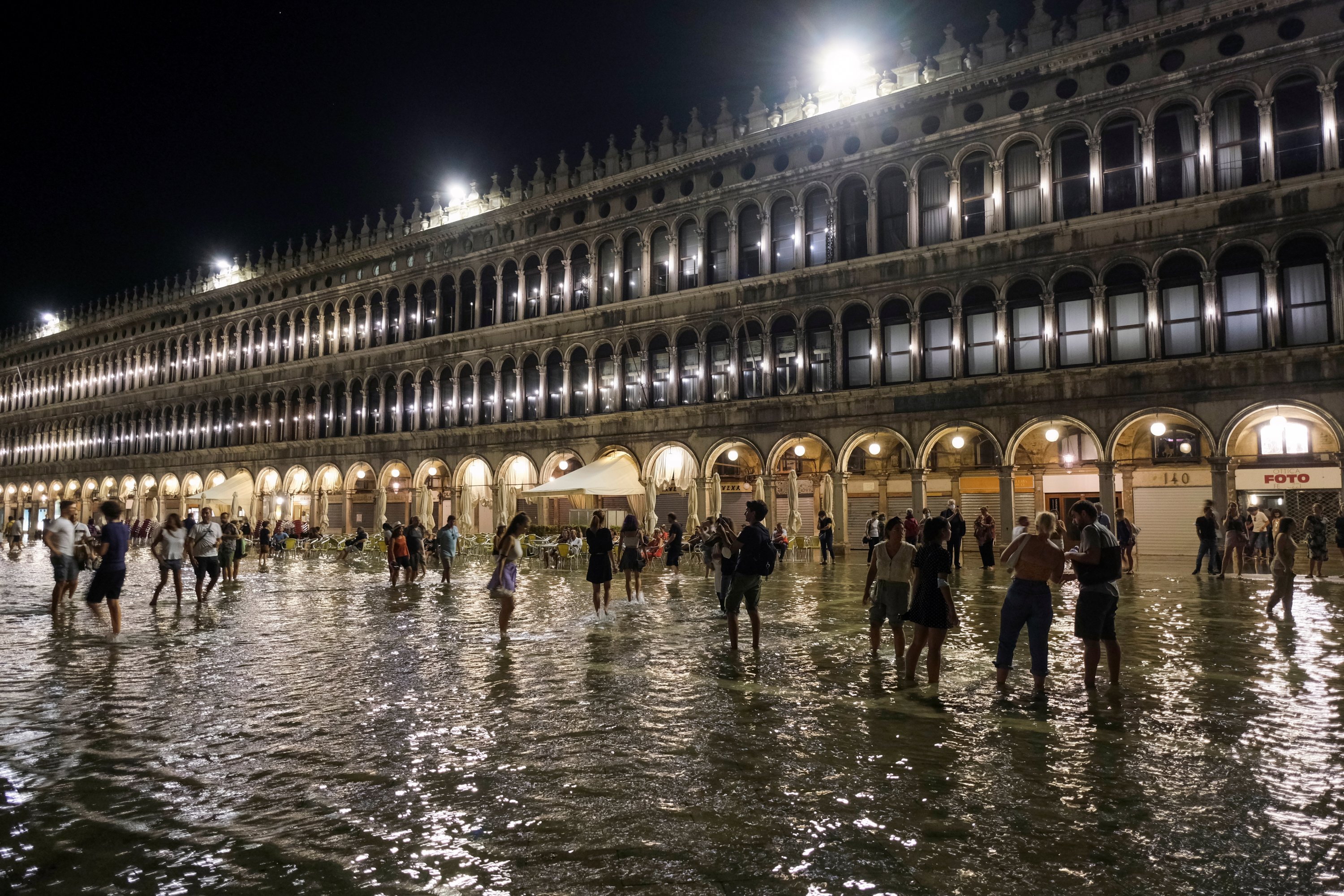 People walk in a flooded St. Mark's Square after waters rose exceptionally high in Venice, Italy, Aug. 8, 2021. (Reuters Photo)