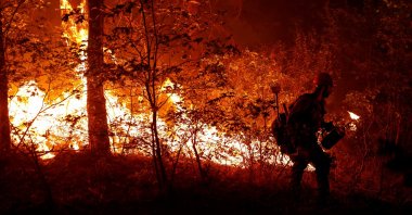 U.S. Forest Service firefighter Ben Foley lights backfires to slow the spread of the Dixie Fire, a wildfire near the town of Greenville, California, U.S., Aug. 6, 2021. (Reuters Photo)