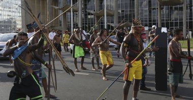 An Indigenous man aims his arrow at police outside the National Congress during a protest for the demarcation of Indigenous lands in Brasilia, Brazil, April 25, 2017. (AP Photo)