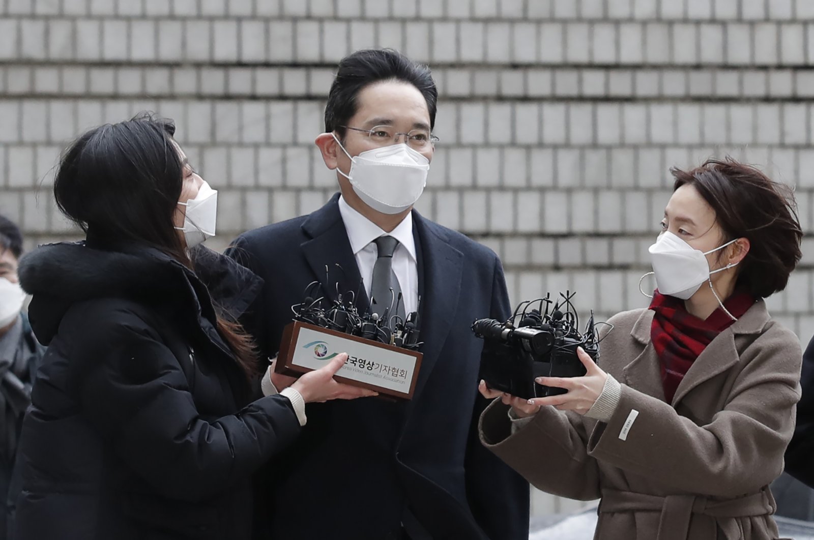 Samsung Electronics Vice Chairman Lee Jae-yong (C) is questioned by reporters upon his arrival at the Seoul High Court in Seoul, South Korea, Jan. 18, 2021. (AP Photo)
