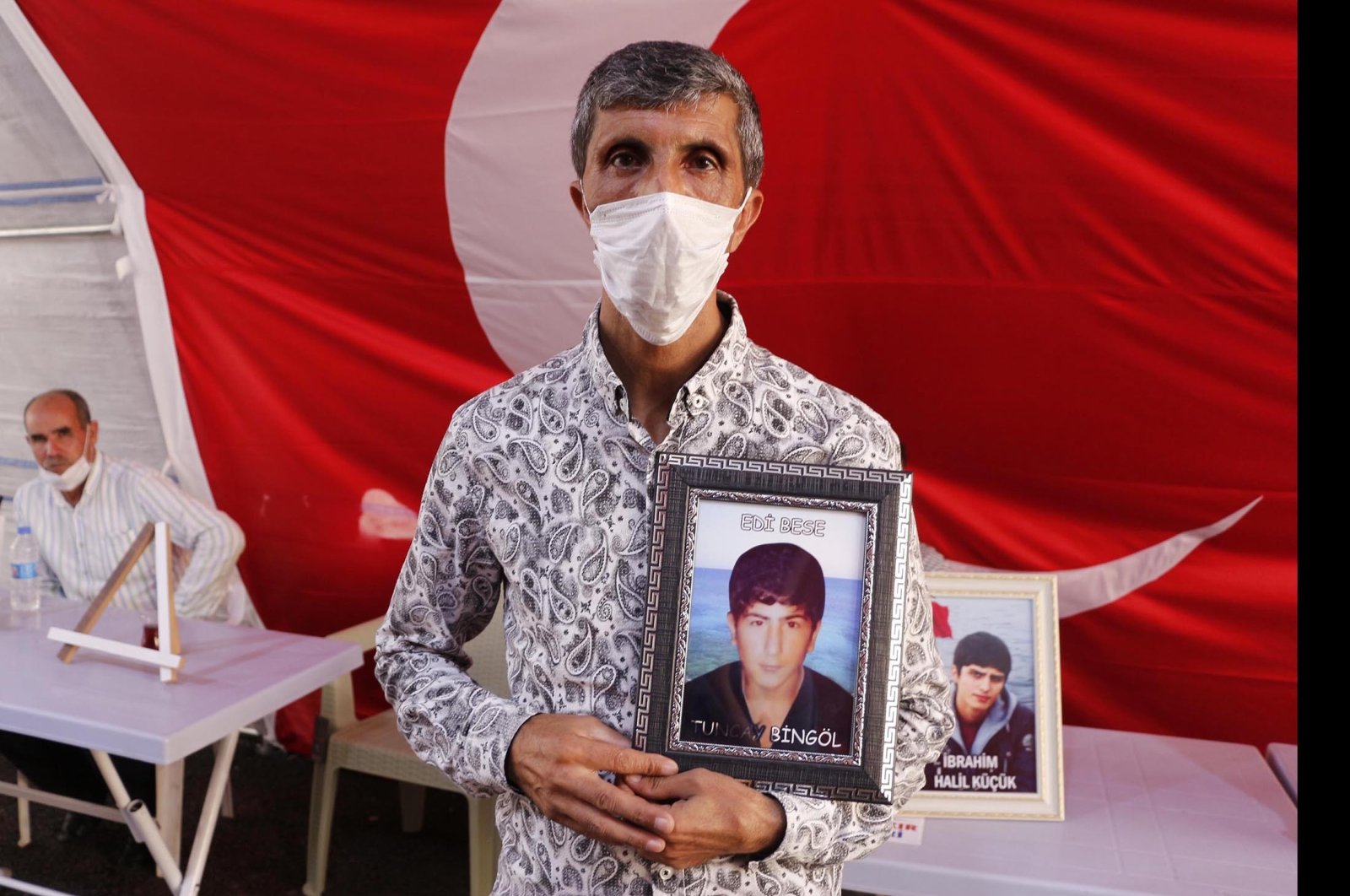 Father Şevket Bingöl holds a picture of his son Tuncay, who was abducted to fight for the PKK terrorists in 2014, Diyarbakır, Turkey, Aug. 6, 2021. (DHA Photo)