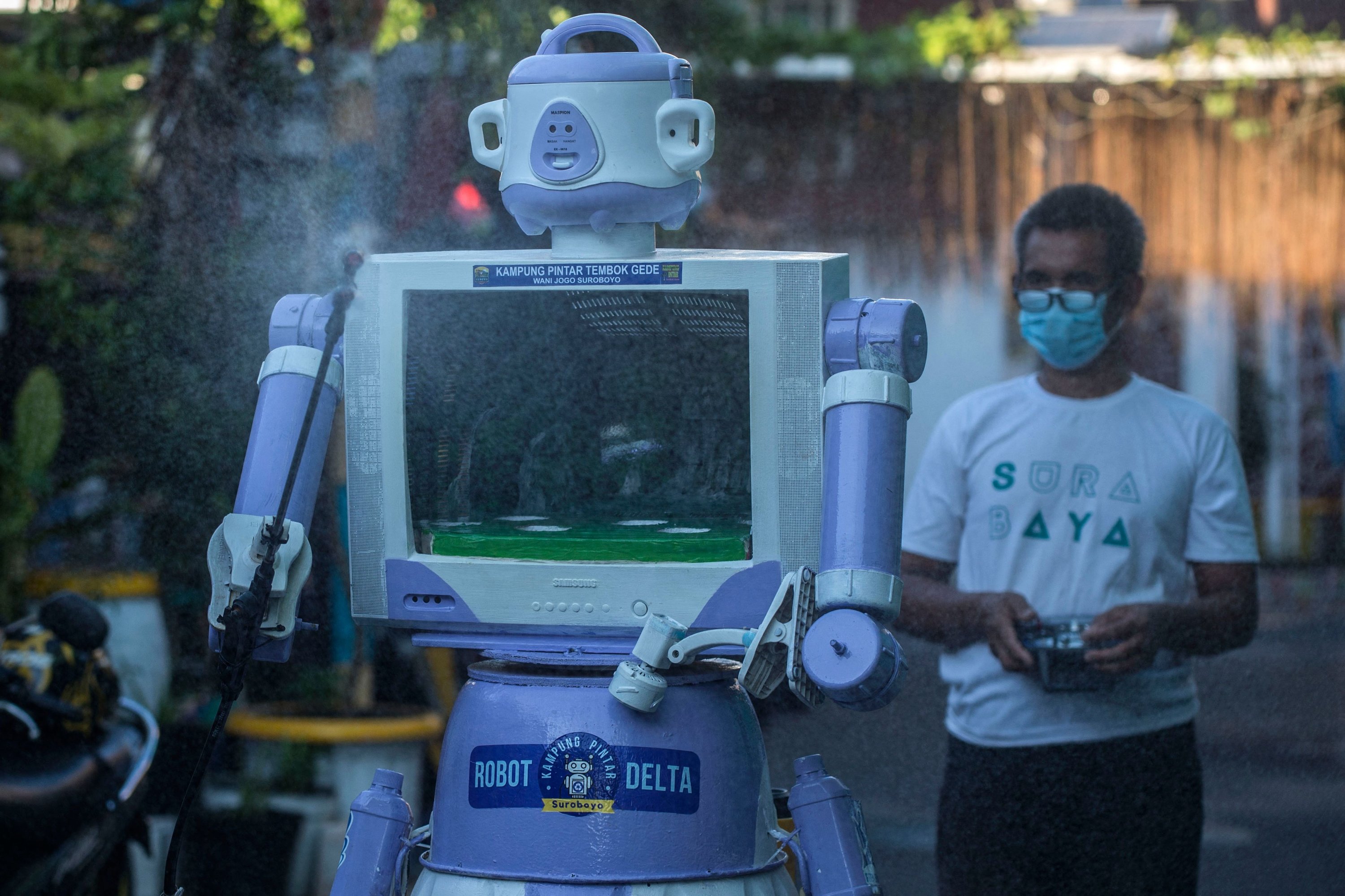 Aseyanto, who goes by one name only, operates a disinfection robot named Delta, which he created from recycled household goods, at a neighborhood in Surabaya, East Java province, Indonesia, on July 28, 2021. (AFP Photo)