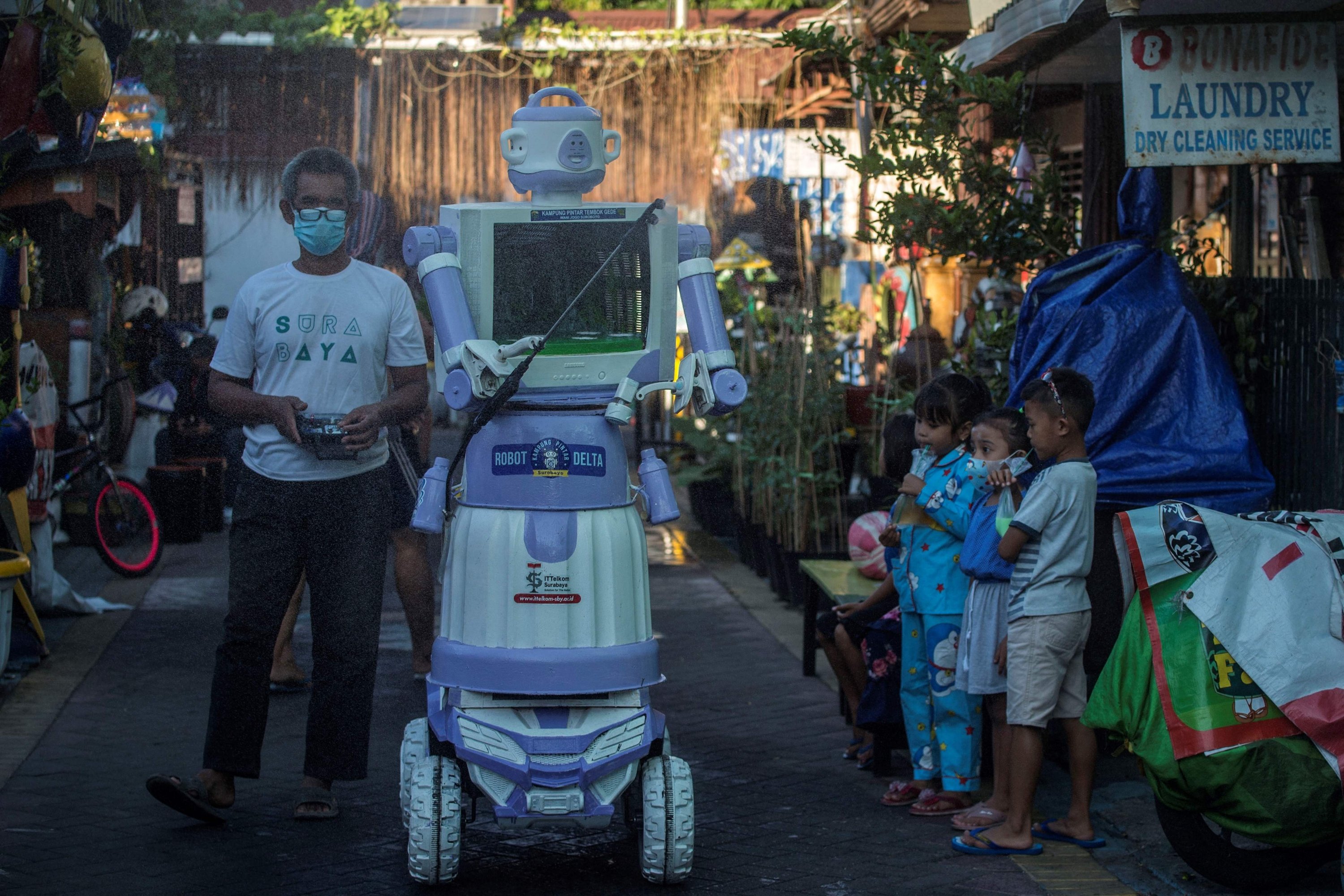 Aseyanto, who goes by one name only, operates a disinfection robot named Delta, which he created from recycled household goods, at a neighborhood in Surabaya, East Java province, Indonesia, on July 28, 2021. (AFP Photo)