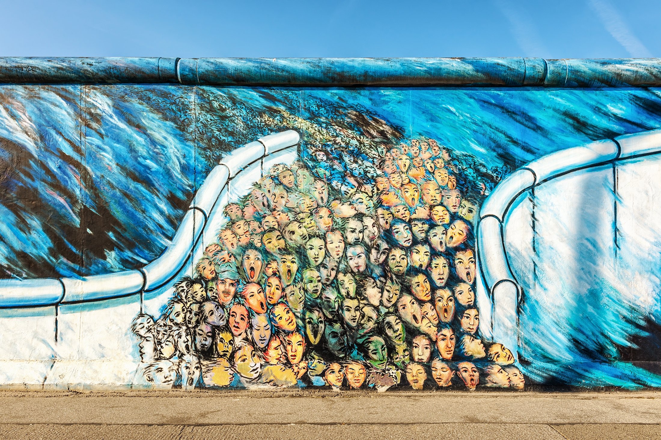 Graffiti art depicting people escaping East Berlin can be seen on a part of the original Berlin Wall at East Side Gallery in Berlin, Germany, Sept. 3, 2011. (Shutterstock Photo)