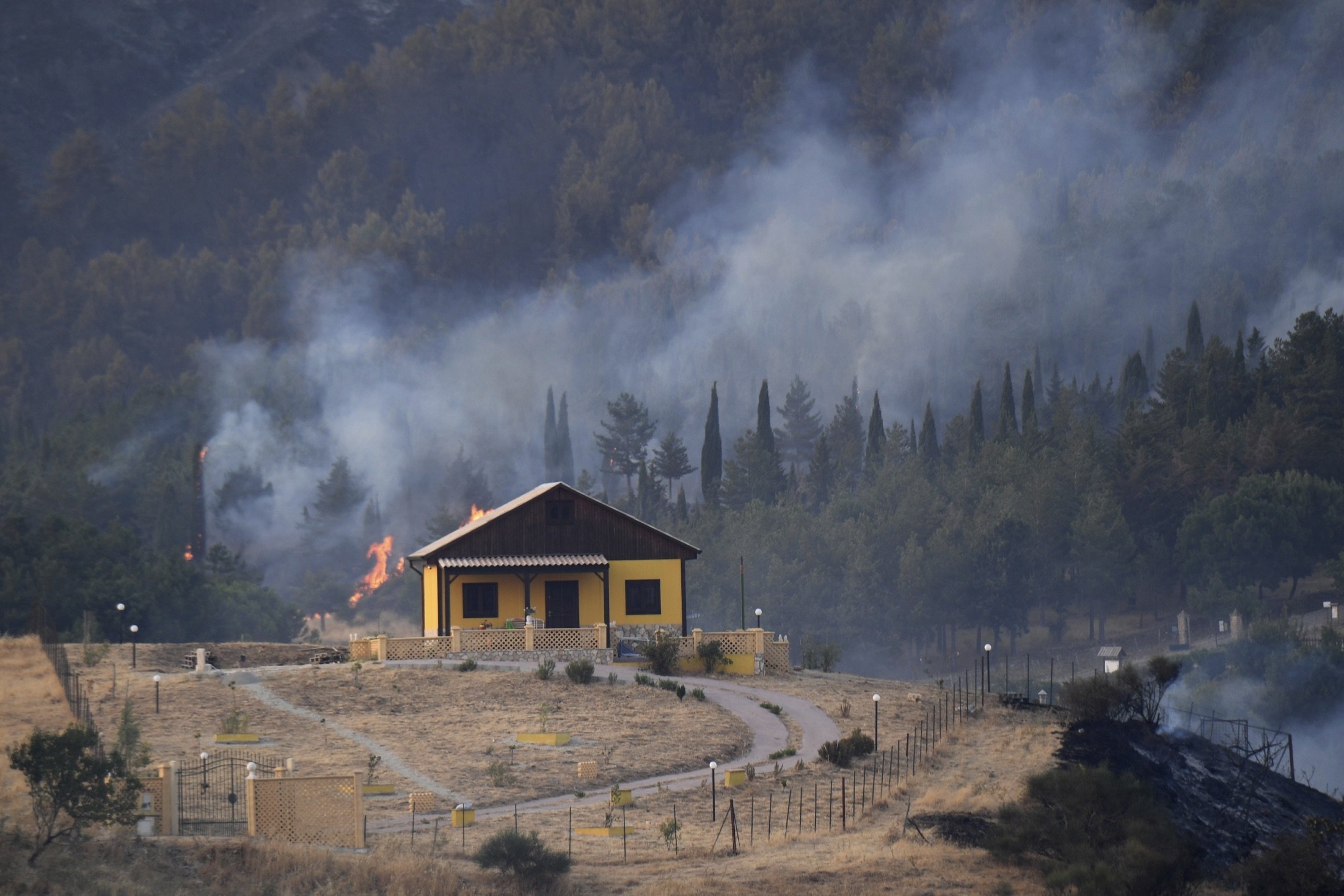 A Canadair drops water on a fire near Petralia Soprana in the upper Madonie as many wildfires continue plaguing the region, near Palermo, Sicily, Italy, Aug. 10, 2021. (AP Photo) 